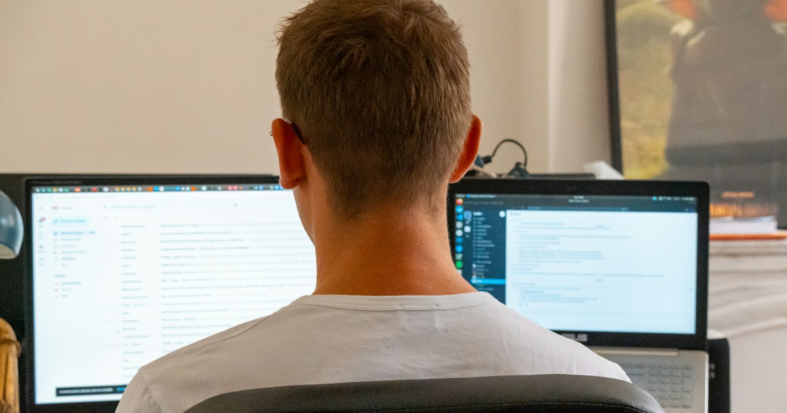 Une personne qui travaille devant deux écrans d'ordinateur
